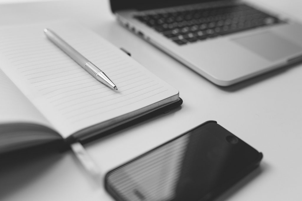 Mesa com bloco de anotações e notebook